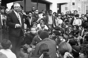 black and white photo of a crowd of black college students listening