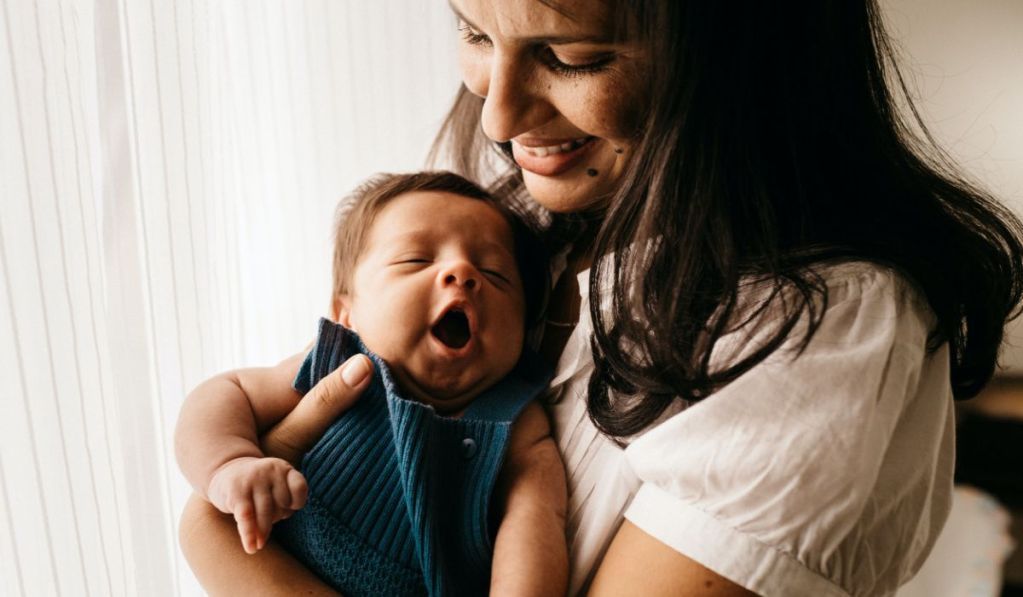 A woman holds an infant.