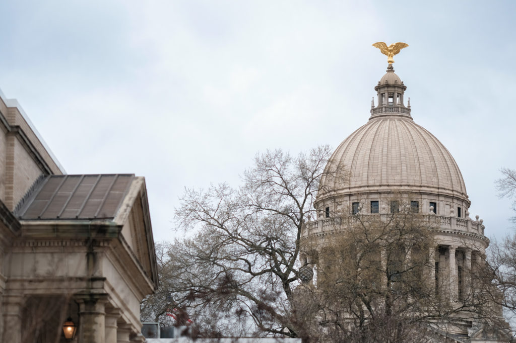 a photo of the Mississippi Capitol building with a gold eagle atop its dome
