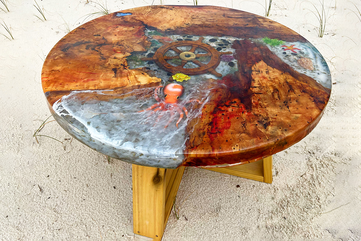 A round table done with ocean themed epoxy art over wooden base