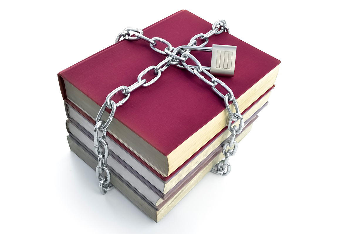 A stack of four books with thick silver chain locked around them