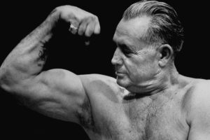 Bodybuilder Charles Atlas flexes his bicep