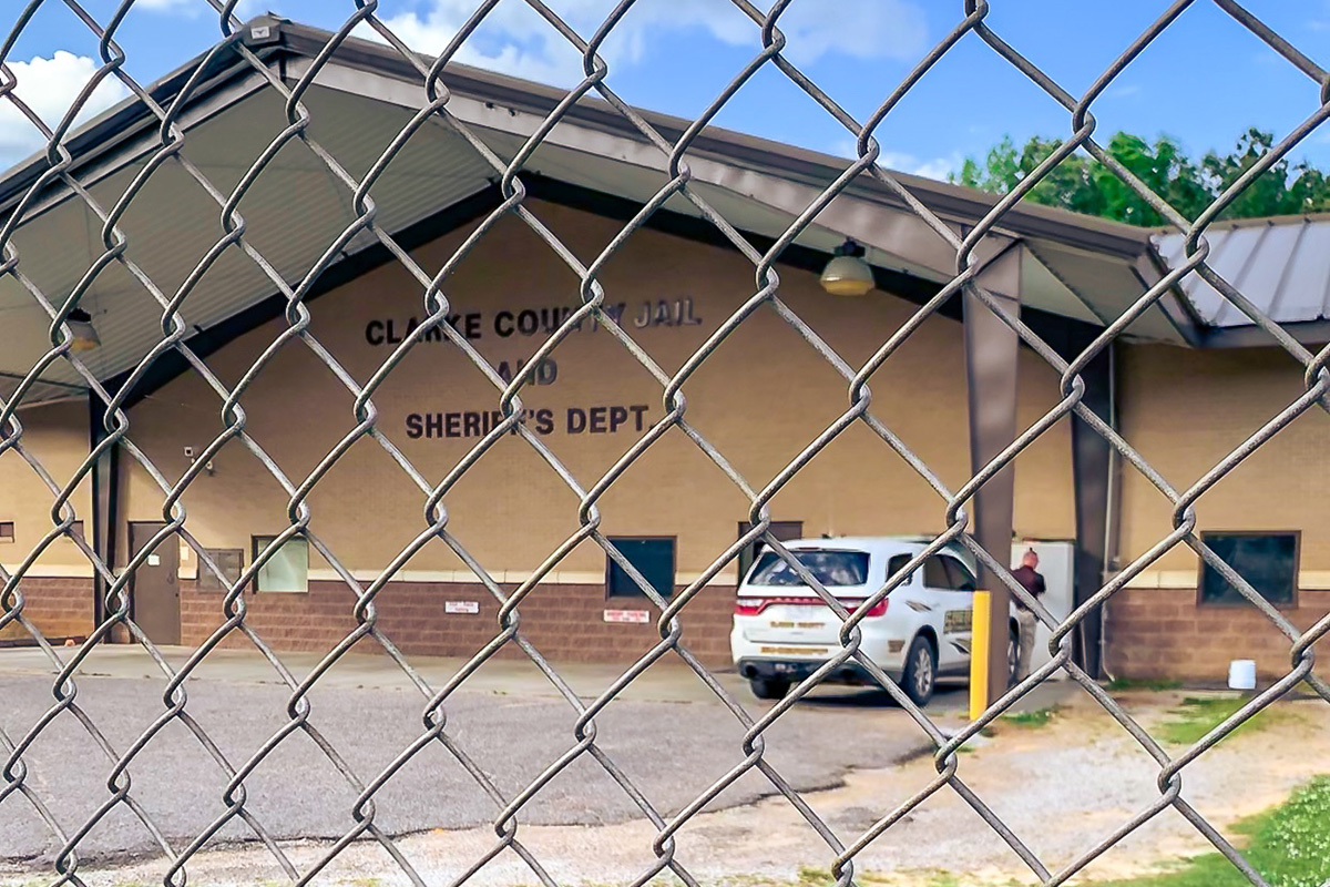 Exterior photo of the Clarke County Jail and Sheriff's Dept as seen through a chain link fence