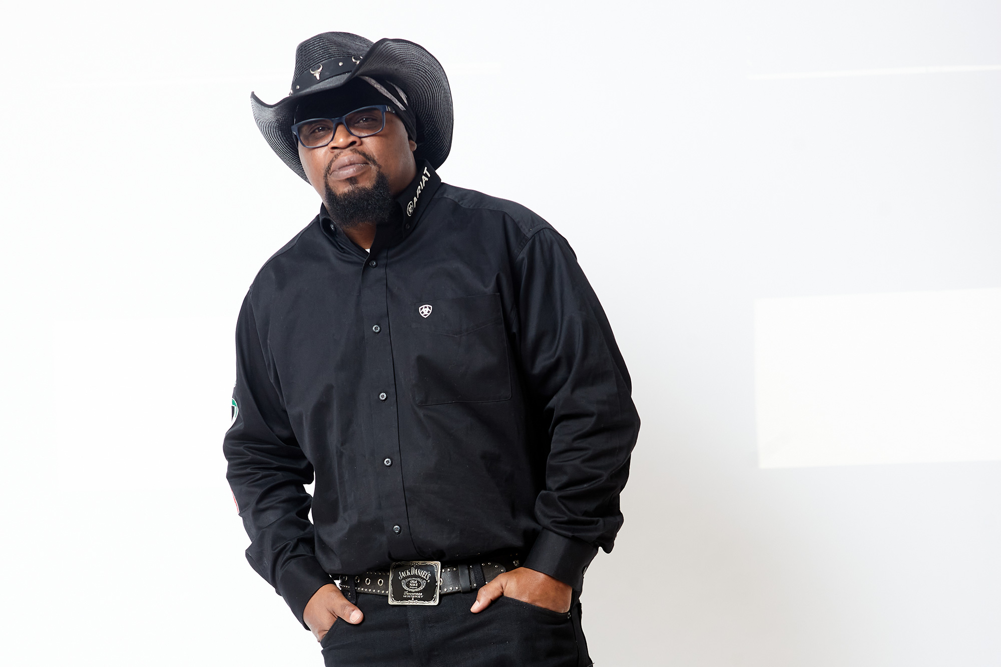 A man in all black clothes and black cowboy hat