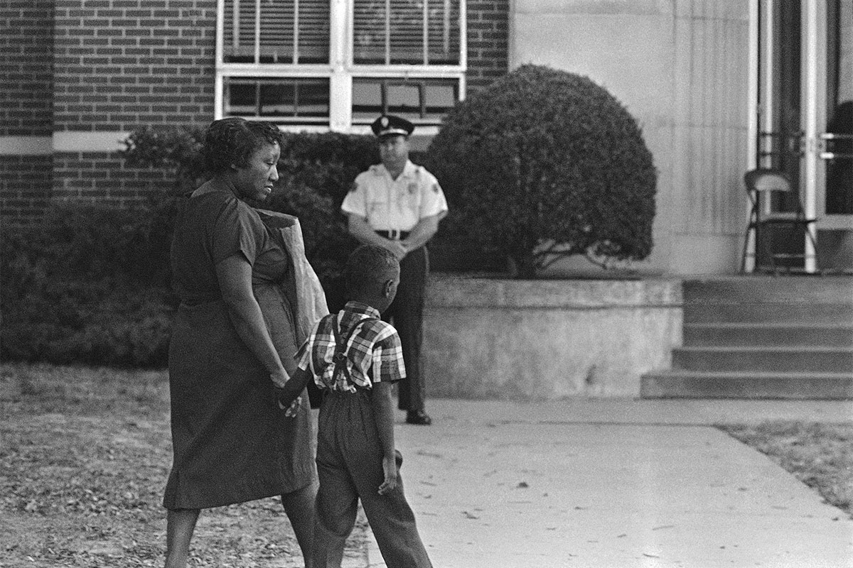 An African American first grader clutches his mother as hand as he arrived for the first day of school (Jackson leadership)