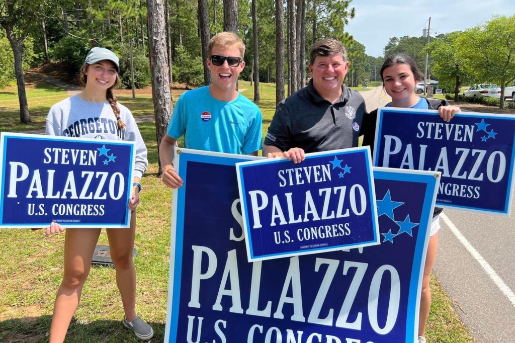 a photo of Steven Palazzo with three young voters holding Palazzo For Congress campaign signs