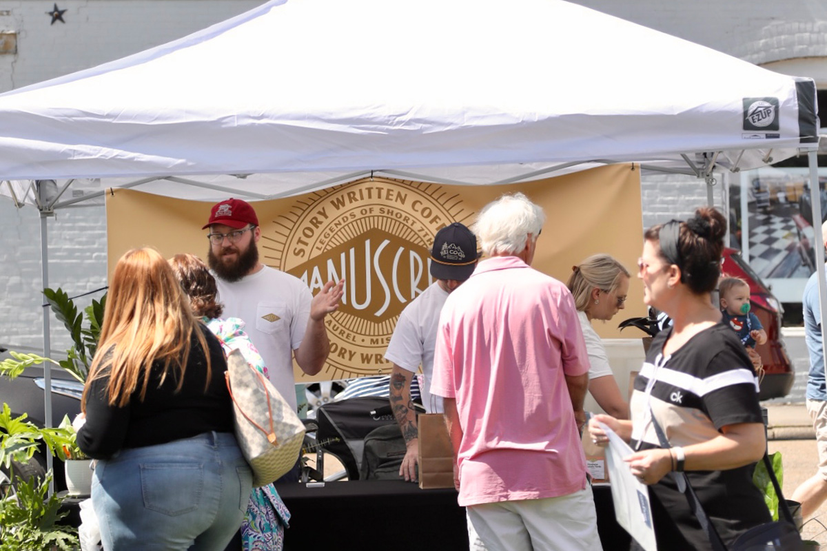 People stand at a tent booth for story written coffee