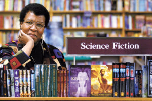 Author Octavia Butler leans against a shelf in a bookstore filled with books she wrote