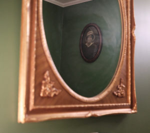 a mirror reflecting an old photograph in a circular frame