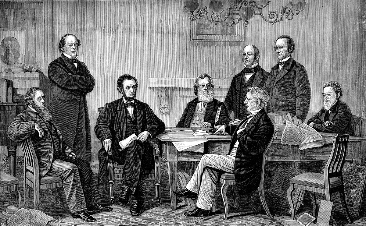 Seven white men gather around a table to watch President Abraham Lincoln sign the Emancipation Proclamation.