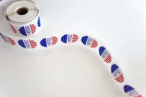 a photo of a roll of I Voted stickers at a polling place for voters