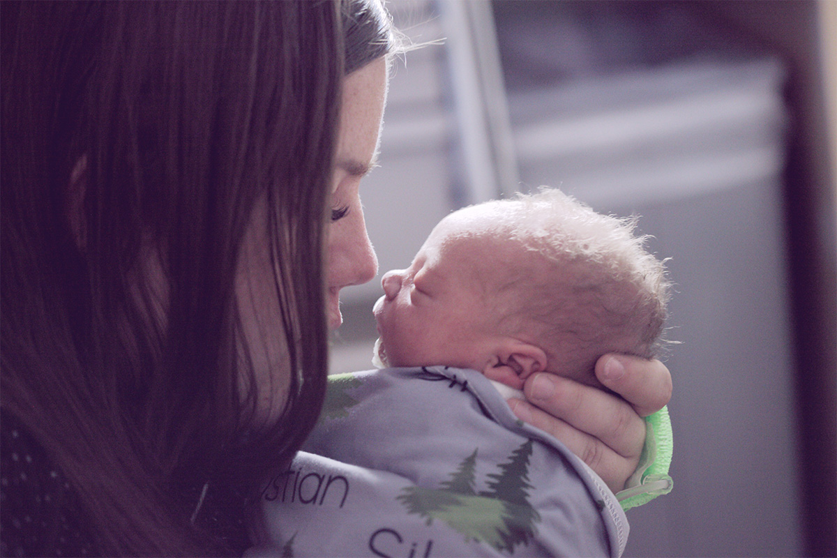Mother cradling a swaddled child