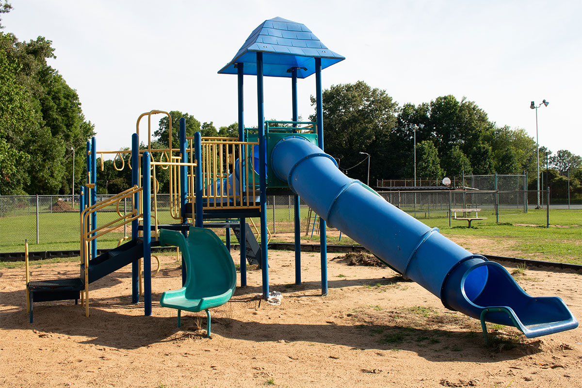 A playground jungle gym with blue slide
