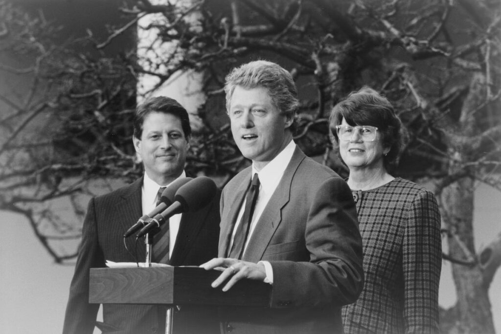 a photo of Bill Clinton standing in front of Janet Reno and Al Gore