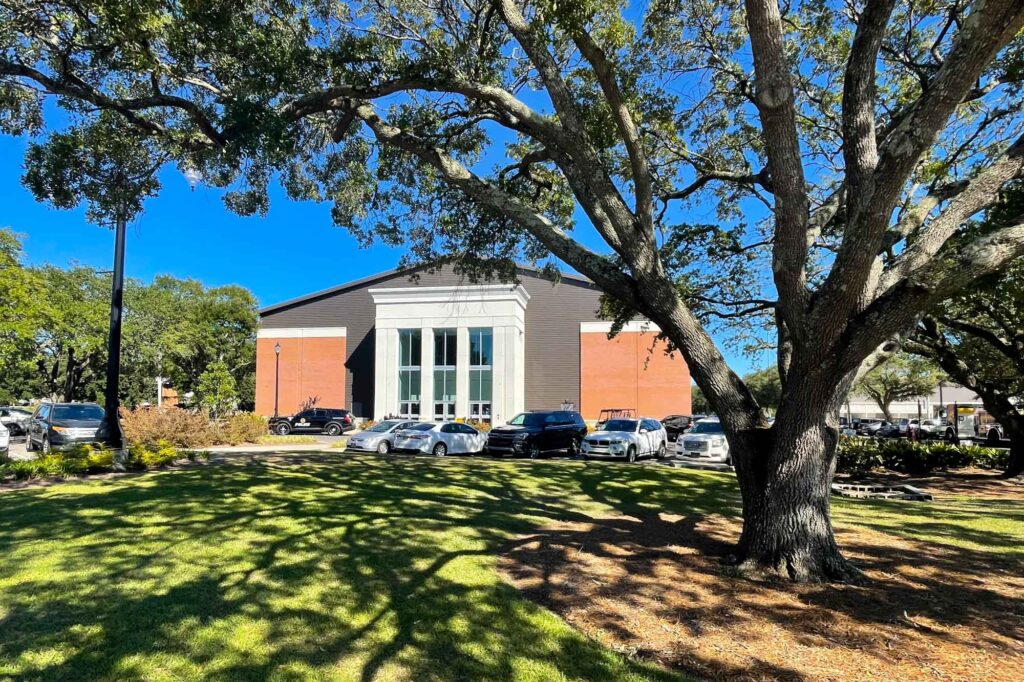 a photo of the USM volleyball stadium seen from around an oak tree
