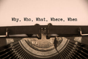 A typewriter with a paper that says Why Who What Where When