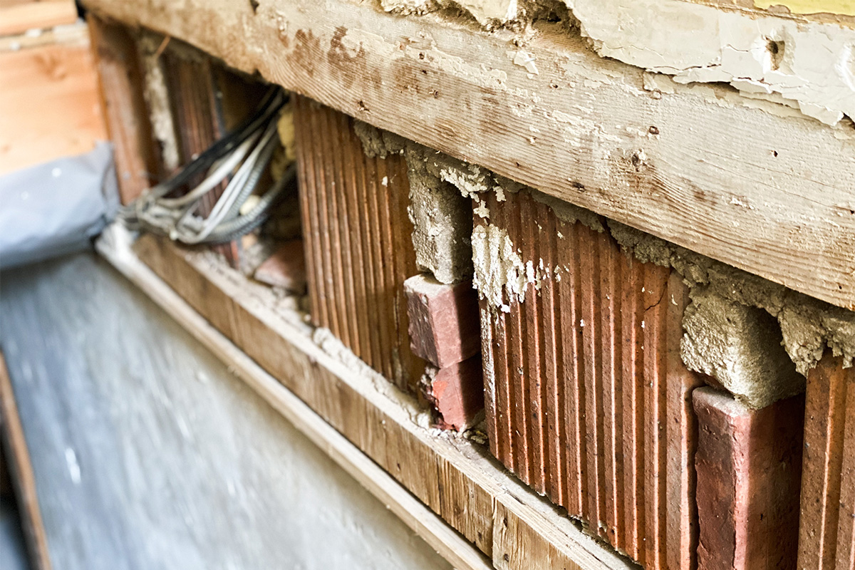 Wood brick and exposed wire on a wall where the drywall was removed due to mold (Black women homeownership)