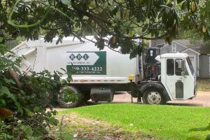 A view of a white garbage truck labeled Richard's Disposal, Inc, on the side in green