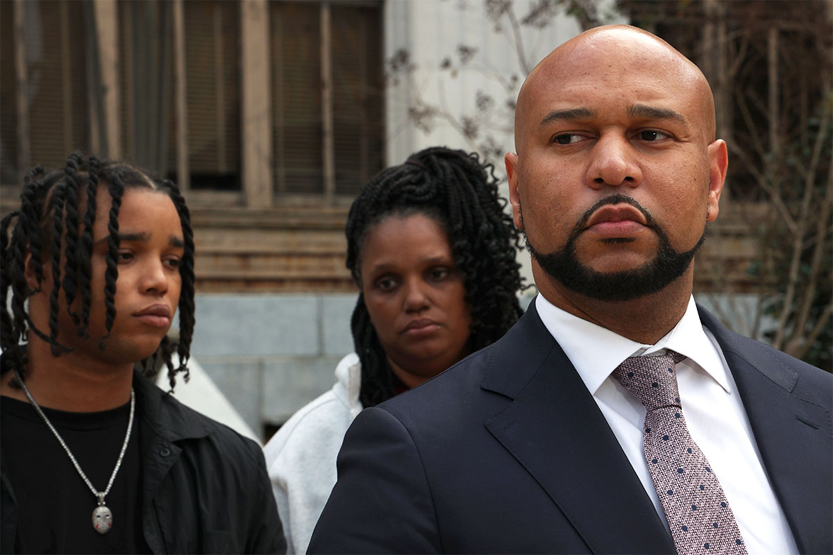 Carlos Moore stands before D'Monterrio Gibson and his mother Sharon McClendon