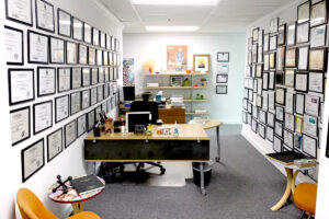 Office filled with two long walls of awards top to bottom