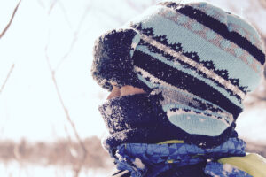 A closeup of a small kid outside in snow gear
