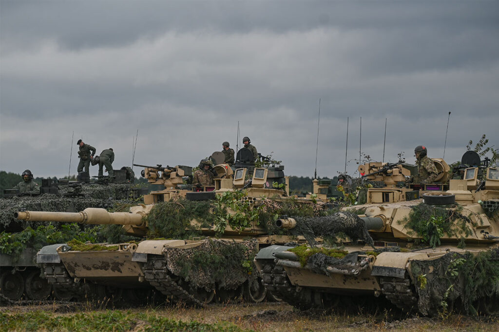 A line of M1 Abrams, a third-generation American main battle tanks, seen in Poland on a cloudy day