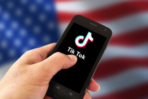 A hand holding a device with the Tik Tok logo on the screen