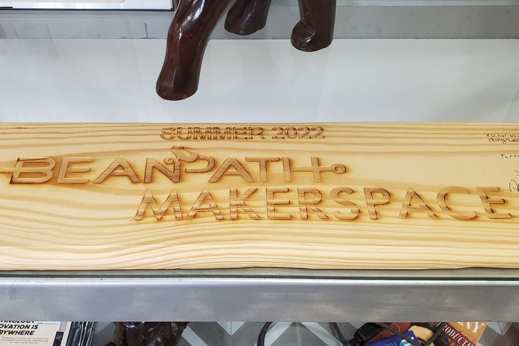 A wood engraved sign that says Summer 2022 Beanpath Makerspace