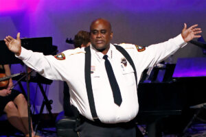Brookhaven, Miss. Police Chief Kenny Collins with arms spread wide on a stage