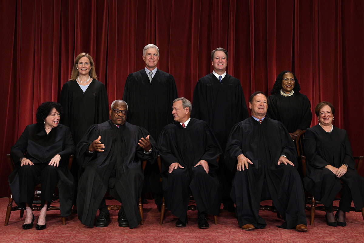 Five men and four women are wearing black robes as they pose for a portrait