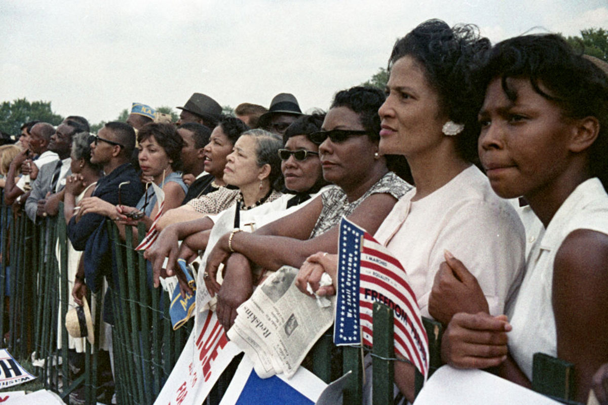 A line of women against a green fence listen during the March on Washington on Aug. 28, 1963. Bettmann Archive/Getty Images