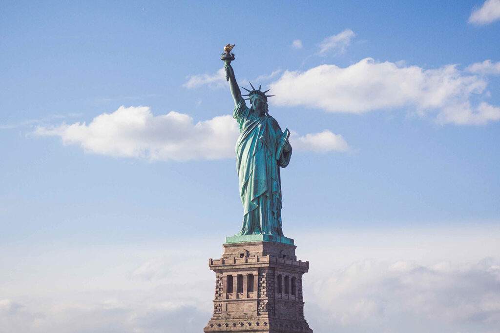 The Statue of Liberty - The statue is a personification of liberty in the form of a woman. She holds a torch in her raised right hand and clutches a tablet in her left.