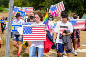 a photo shows young supporters of abortion rights protesting holding signs with the words "Abortion Freedom Fighters" at the top and an American flag