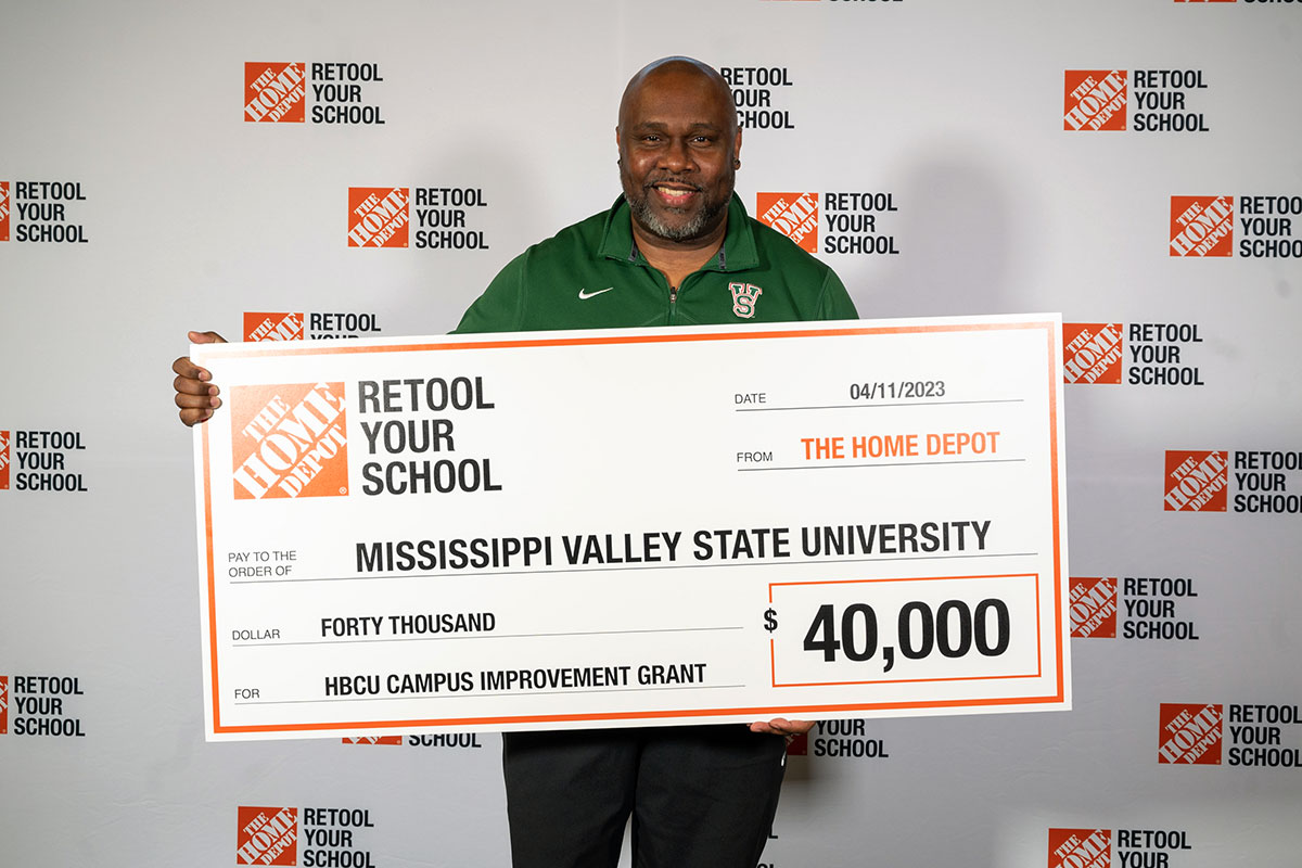 A man from Mississippi Valley State University holds a check for $40,000