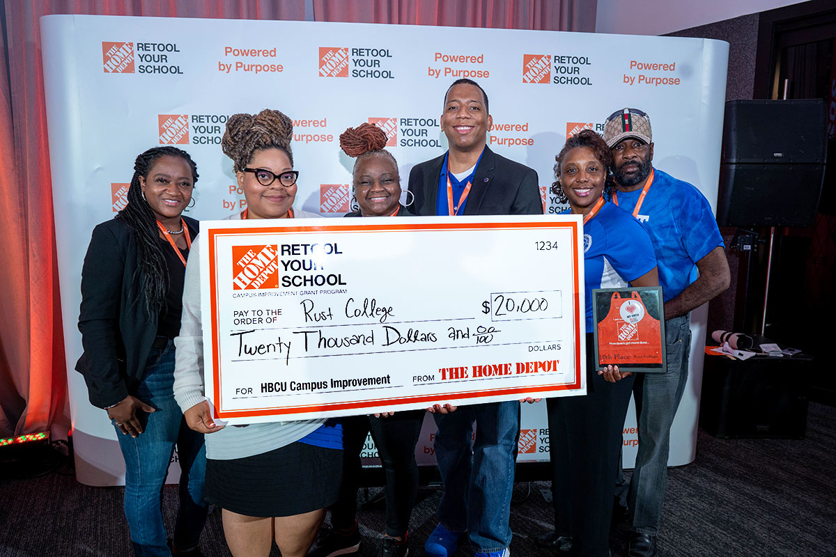 Six people from Rust College hold a check for $20,000