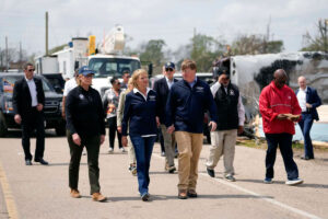 Gov. Tate Reeves, center, walks hand-in-hand with Mississippi First Lady Ellie Reeves while touring tornado damage in Rolling Fork, Miss