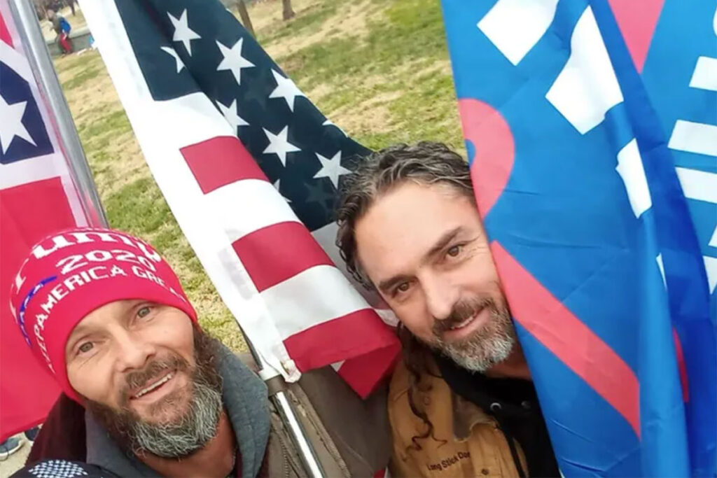 Thomas Smith and Donnie Wren in a selfie holding US flags and TRUMP 2020 flags.