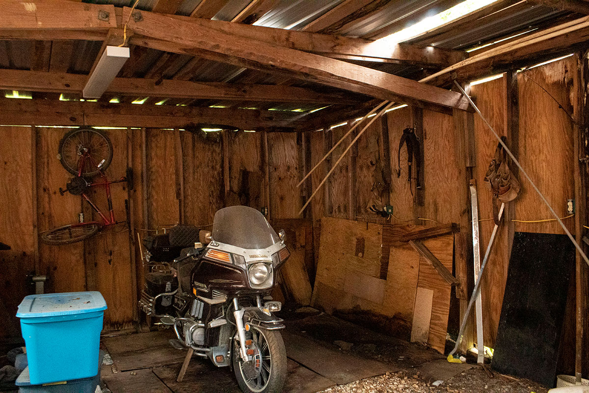 A motorcycle is parked in a wooden shed