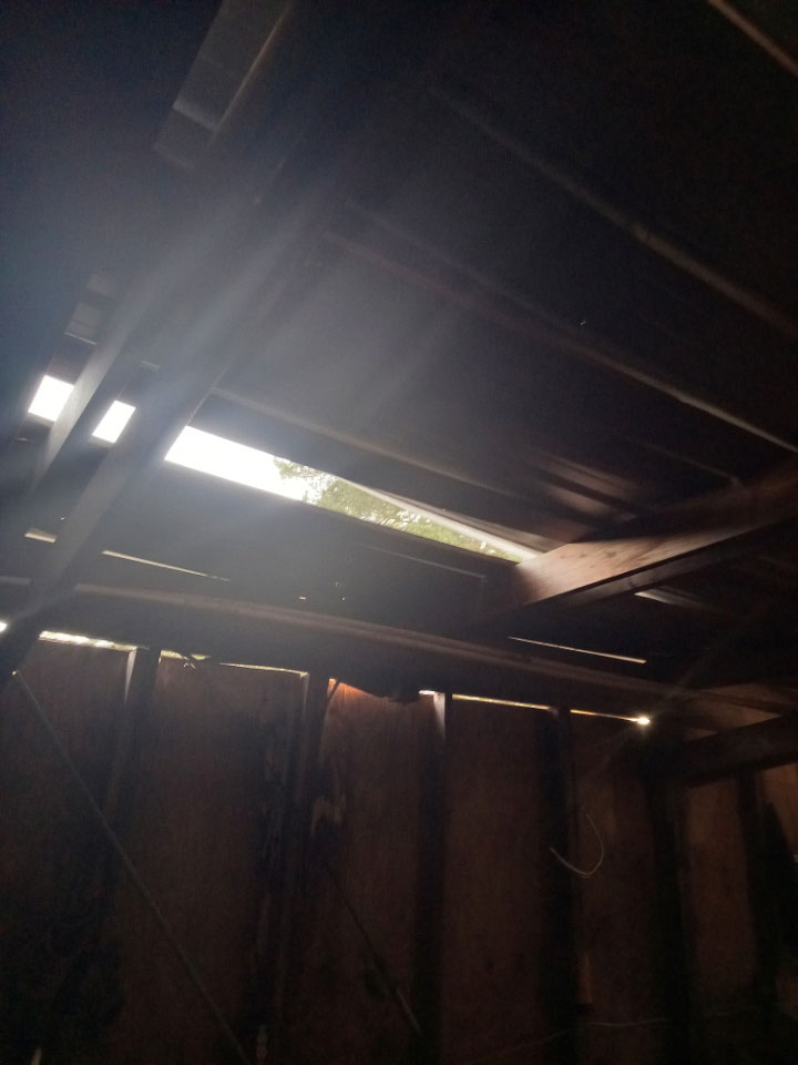 A missing board in a roof lets sunlight in