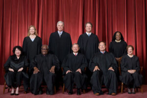 US Supreme Court justices sitting and standing in black robes
