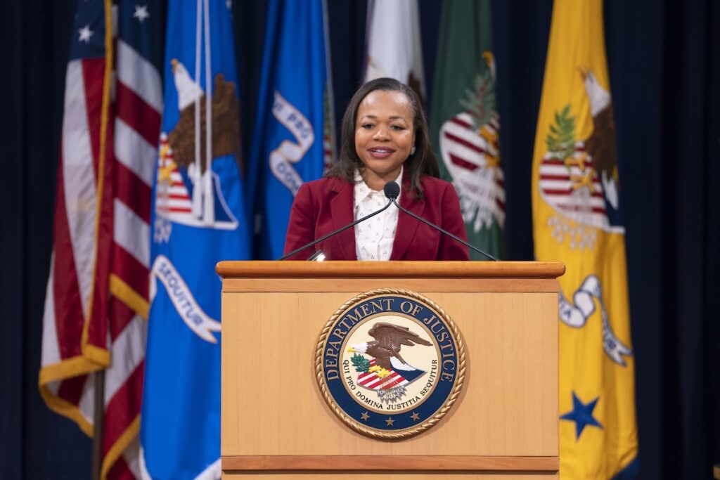 a photo of Kristen Clarke at a U.S. Department of Justice podium
