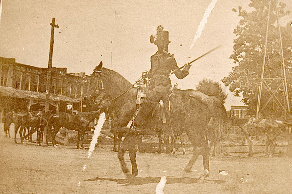 Joshua Houston riding a horse in a Juneteenth Parade through a town square