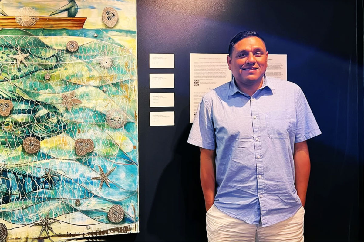 Paul Mora standing beside a piece of seaside art