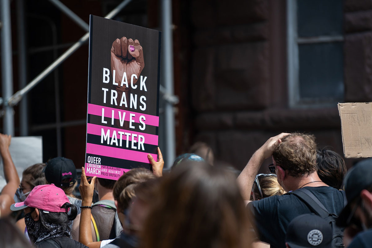 A demonstrator holds a sign a that supports Black Trans people