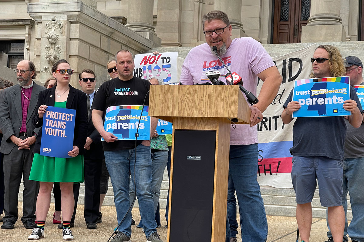 Several people stand in front of the Mississippi Capitol Building holding signs such as "Protect Trans Youth" and "No to HB 1125"