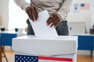 Black man putting vote in voting box