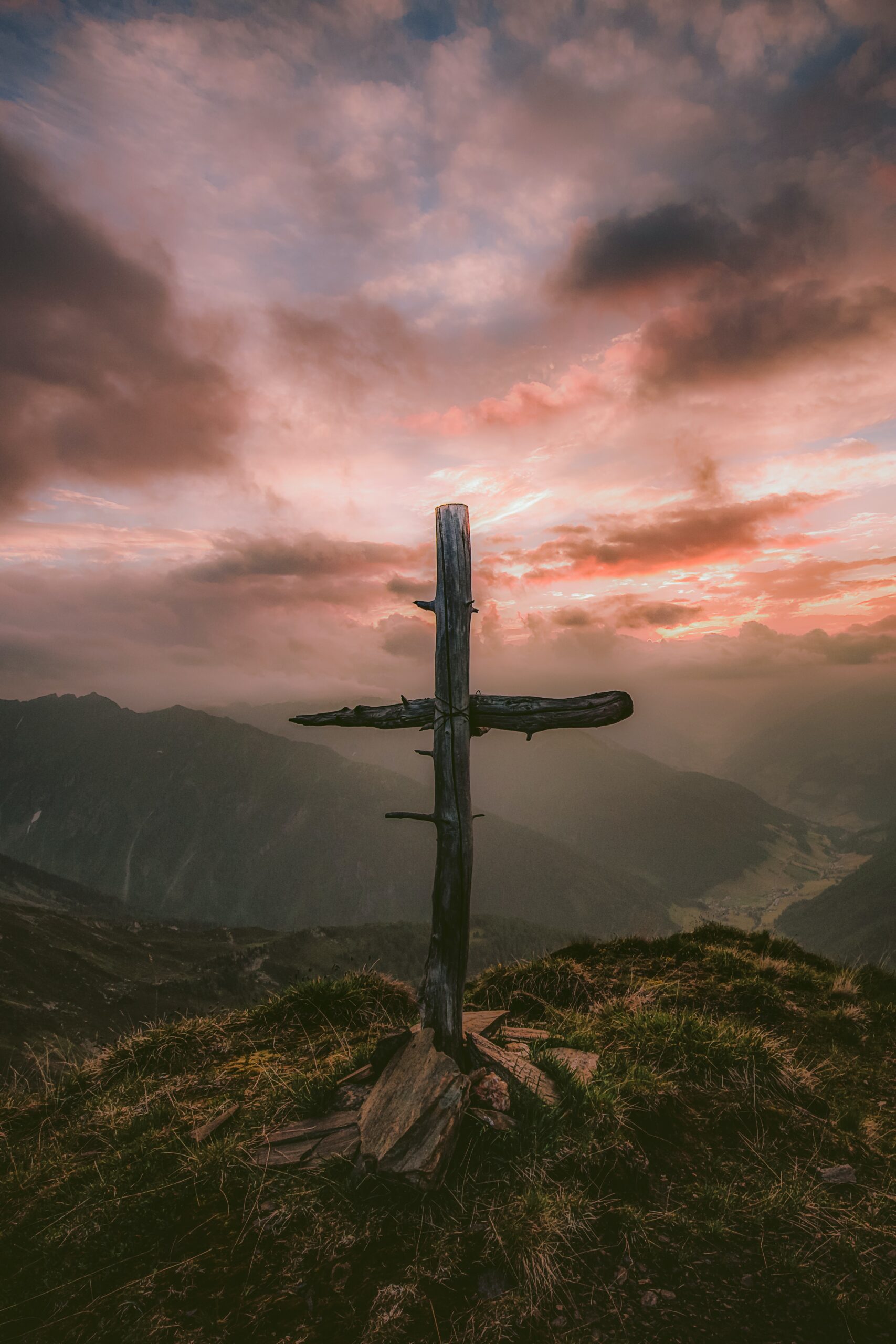 wooden cross on top of a mountain