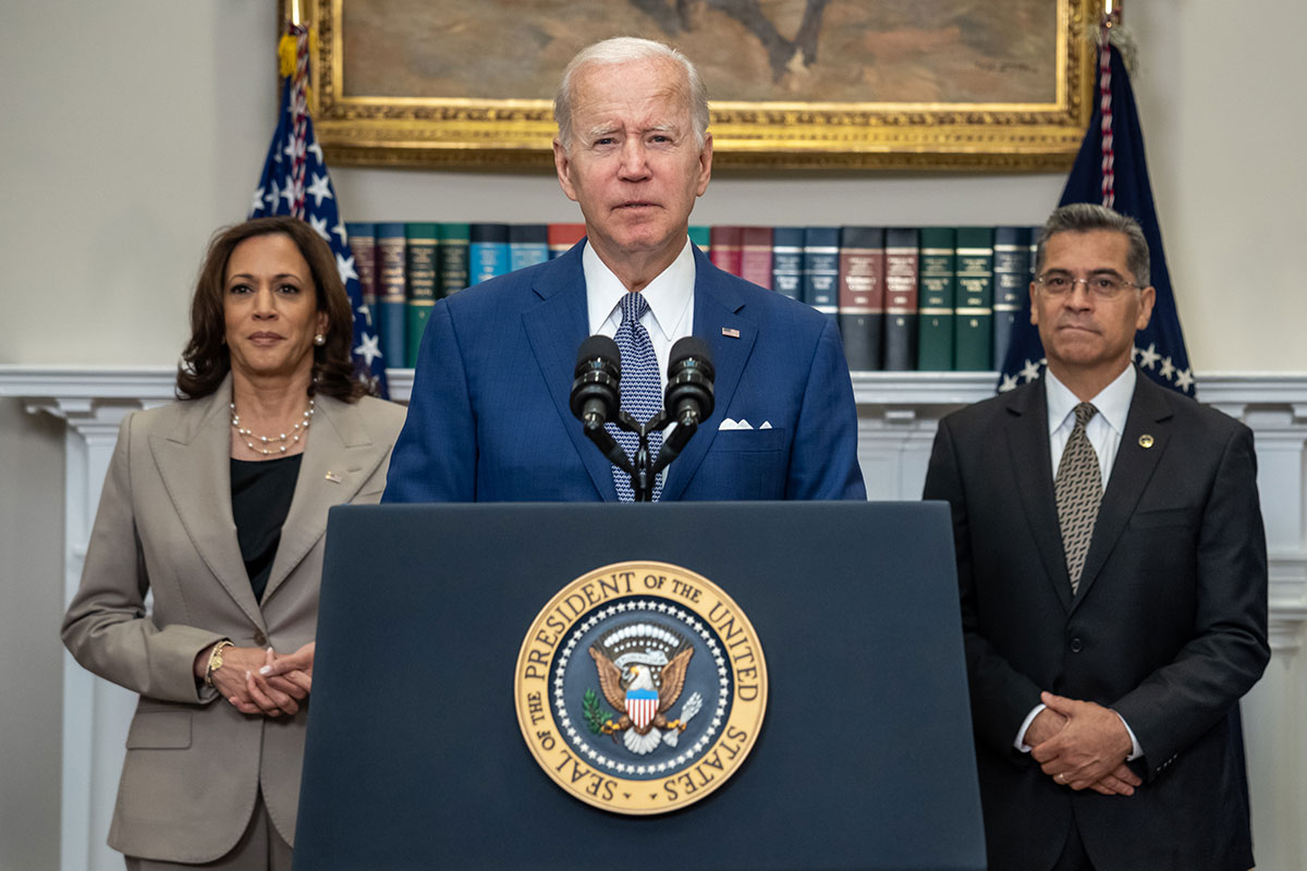 President Joe Biden at a podium inside the White House, joined by Vice President Kamala Harris, Secretary of Health and Human Services Xavier Beccera
