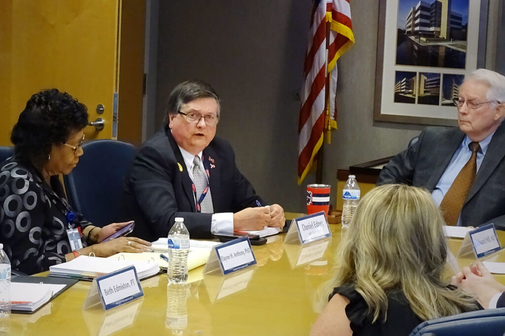 Dr. Dan Edney sits at a table with four other people on the State Board of Health