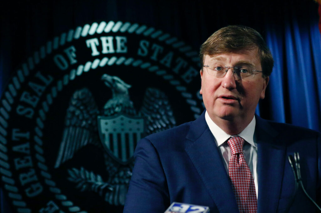 Tate Reeves speaking in front of the state seal